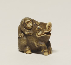 Netsuke of a monkey pulling a wild boar's ear